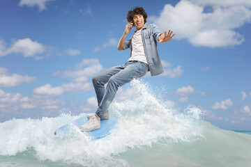 Sticker - Man in jeans surfing on a surfboard and using a smartphone