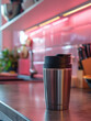 © SashaMagic - Stainless steel travel mug on a modern kitchen counter.
