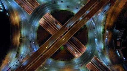 Wall Mural - Financial technology, energy power, beautiful top view time-lapse of car traffic at roundabout lane and buildings. 4K drone aerial zoom out. Urban cityscape concept or abstract of advanced innovation.