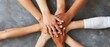 © Rock  - Close up of young people's hands together in a team huddle on a grey background, from a top view