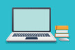 © Tanu - A laptop with a blank screen sits on a blue desk next to a stack of three books and a wireless mouse.