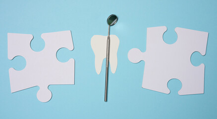 Dentist's medical mirror and white paper puzzles on a blue background