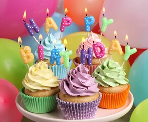 Wall Mural - Birthday cupcakes with burning candles on stand near color balloons