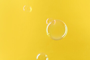 Canvas Print - Beautiful transparent soap bubbles on yellow background