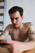 © ADDICTIVE STOCK - Introspective young man with intricate body tattoos