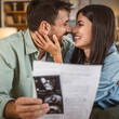 © Miljan Živković - Happy pregnant woman with her husband watch ultrasound photo of baby