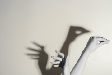 Wall Mural - Shadow puppet. Woman making hand gesture like swan on light background, closeup with space for text. Black and white effect