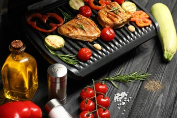 Wall Mural - Electric grill with different products on black wooden table