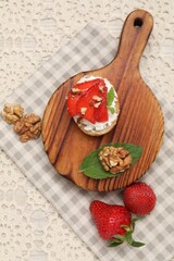 Wall Mural - Delicious ricotta bruschetta with strawberry and walnut served on table, flat lay
