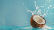 © Alexandra - Coconut splashing into water creating a refreshing crown of water drops on a blue background with copy space
