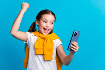 Poster - Photo of sweet lucky small girl wear tied pullover winning game modern gadget empty space isolated blue color background