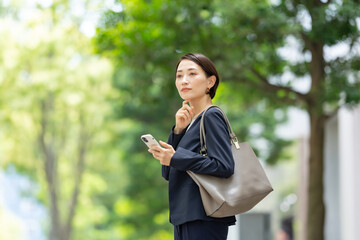 Canvas Print - スマートフォンを持つ悩むビジネス女性