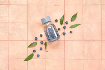 Wall Mural - Sports bottle of infused water with blueberries and leaves on pink tile background