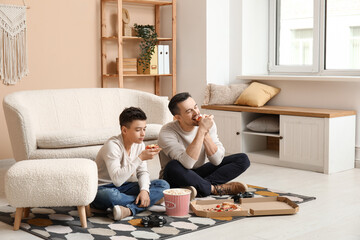 Wall Mural - Happy father and his little son with tasty food at home