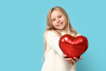 Wall Mural - Cute little girl with heart shaped air balloon on blue background. Valentine's day celebration