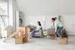 © Pixel-Shot - Happy young couple carrying armchair in room on moving day