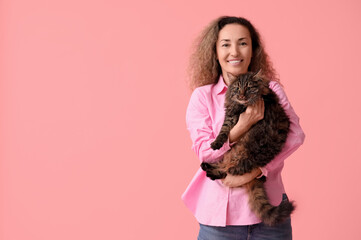 Wall Mural - Mature woman with cute cat on pink background