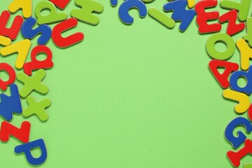 Poster - Learning alphabet. Magnetic letters on green background, flat lay. Space for text