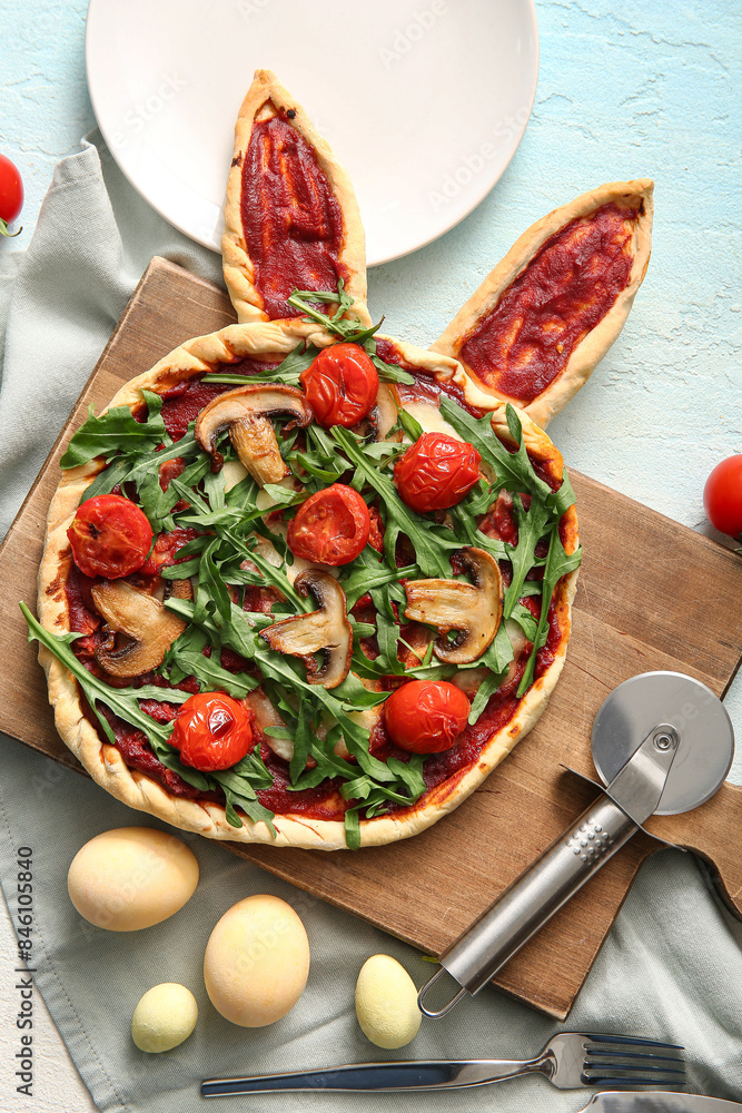 Composition with tasty pizza and painted eggs for Easter celebration on blue background