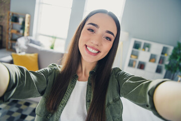 Wall Mural - Portrait of nice young girl beaming smile make selfie wear green shirt modern interior flat indoors