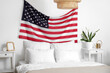 © Pixel-Shot - Interior of light bedroom with USA flag above cozy bed