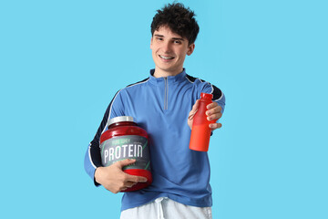 Canvas Print - Sporty young man with protein powder and shake on blue background