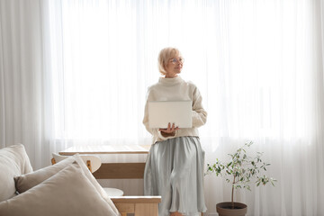 Wall Mural - Middle-aged woman with laptop at home