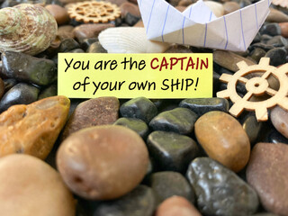 Inspirational and motivational quote - you are the captain if your own ship written on notepaper background. Stock photo.