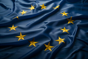 Top view of the twelve yellow stars of a European Union blue flag, made of satin fabric.