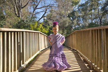 Wall Mural - Girl dancing flamenco, posing looking at the camera, in typical flamenco dress, on a wooden bridge. Concept dance, flamenco, typical Spanish, Seville, Spain.