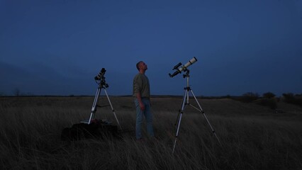 Wall Mural - amateur astronomer looking at the evening skies, observing planets, stars, moon and other celestial 