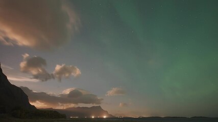 Wall Mural - The mesmerizing dance of the Aurora Borealis as it lights up the clouds against the backdrop of a vibrant sunset sky, creating a breathtaking celestial spectacle.