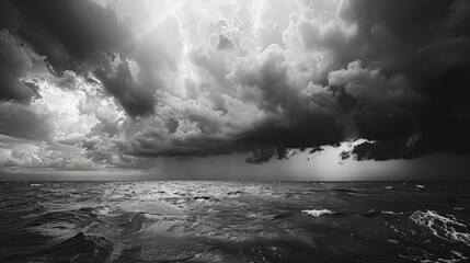 Wall Mural - a black and white photo of a stormy ocean with dark clouds