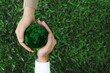 © witsarut - Two hands holding green earth together on nature background for the Sustainable Development Goals. Responsibility for the environment.Global community teamwork. Ecosystem. Save world.