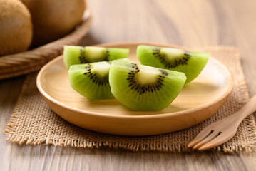 Wall Mural - Sliced green kiwi fruit on wooden plate ready to eating, Healthy fruit