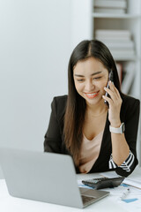 Wall Mural - Shot of an Asian young businesswoman working on a laptop computer in her workstation.Portrait of Business people employee freelance online marketing