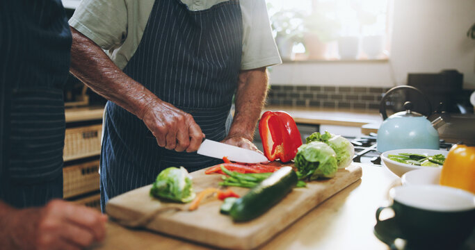 Hands, people and cutting board in kitchen with help, support and teaching at home for healthy food. Chef with knife for cooking lunch and nutrition with bell pepper, cucumber and green vegetables