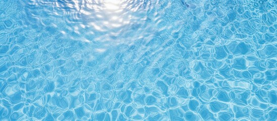 Wall Mural - Aerial view of sunlight reflecting on the water surface of a blue tiled swimming pool creating a patterned background with ample copy space image