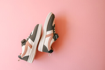 Wall Mural - Children's sneakers on a pink background, style and fashion