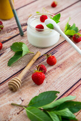 Poster - homemade sweet yogurt in a jar with strawberries, on a wooden table