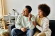 © Bliss - Good looking African American woman helping her husband with hearing aid while at home.