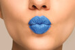 © New Africa - Woman with light blue lipstick sending air kiss, closeup view
