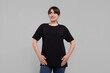 © New Africa - Smiling woman in stylish black t-shirt on light grey background