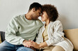© Bliss - An African American couple sitting on sofa.