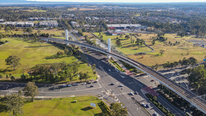 Canvas Print - Aerial drone view of a train heading toward Tallawong Station on the metro northwest railway line, Greater Sydney, NSW Australia crossing the railway bridge in June 2024 