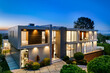© Wirestock - Contemporary house with city lights visible from the balcony