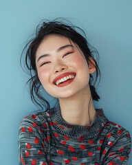 Wall Mural - A Asian female model, captured mid-laugh with her head slightly tilted back, wearing a fashionable outfit, against a solid light blue background. The lighting is soft and natural.