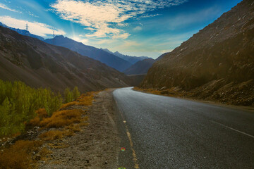 Wall Mural - Mountain landscape with grassy slopes and winding roads marked with yellow lines