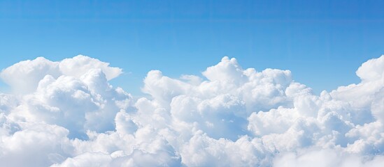 Aufkleber - Fluffy white clouds floating in a clear blue sky providing ample empty space for an image