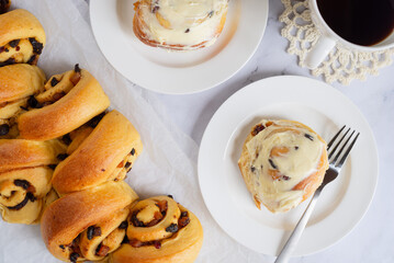 Wall Mural - cinnamon mixed fruit slice bun with cream cheese frosting on white ceramic plate.